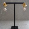 Närbild på Classy Pearls örhängen i guld med oregelbundna pärlor