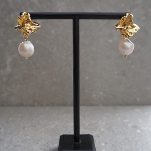 Närbild på Classy Pearls örhängen i guld med oregelbundna pärlor