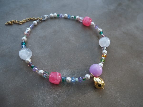 Färgglatt halsband med glaspärlor, sötvattenspärlor och guldfärgad berlock från HAPPY Collection
