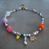 Handgjort halsband med färgade glaspärlor, sötvattenspärlor och dekorativa detaljer