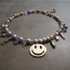 Unikt statement-halsband med smiley, skimrande cubic zirconia och naturliga snäckskalspärlor.