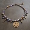 Guldfärgat halsband med smileyberlock och pärldetaljer i en lekfull design från HAPPY-kollektionen.
