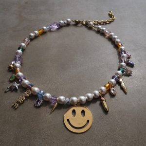 Guldfärgat halsband med smileyberlock och pärldetaljer i en lekfull design från HAPPY-kollektionen.