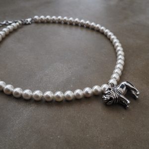 Ett pärlhalsband med ett urgullig silverfärgad bulldog