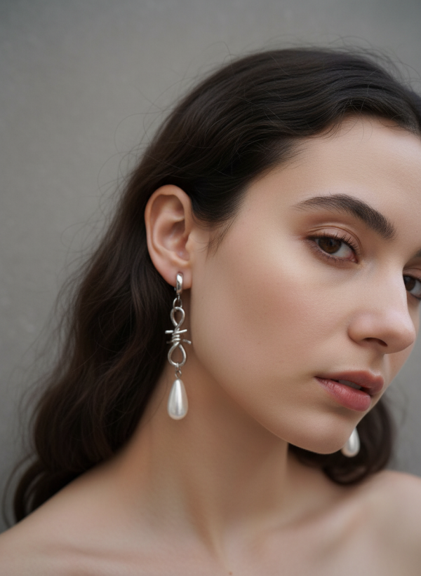 Barbed wire earrings i rostfritt stål på modell, kombinerar rockig och romantisk stil.