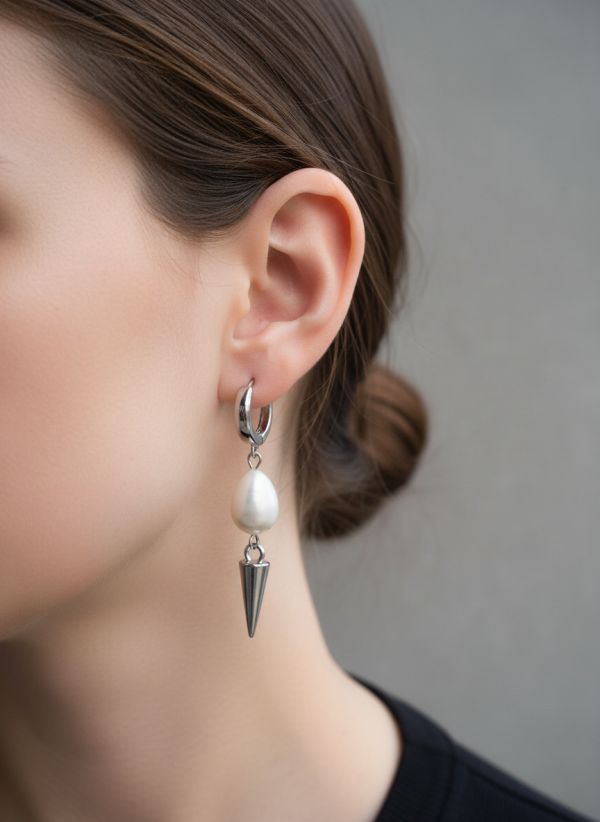 Silverfärgade örhängen med spike och droppformad pärla från By Bertlett