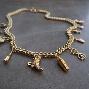 Guldfärgat halsband med berlocker som hjärta, solglasögon och vinglas